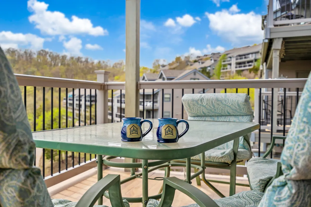 An inviting private deck with a table, comfortable chairs, and scenic lake views. The setup is ideal for morning coffee, relaxed conversations, and soaking in the tranquil surroundings, blurring the line between indoor and outdoor living.