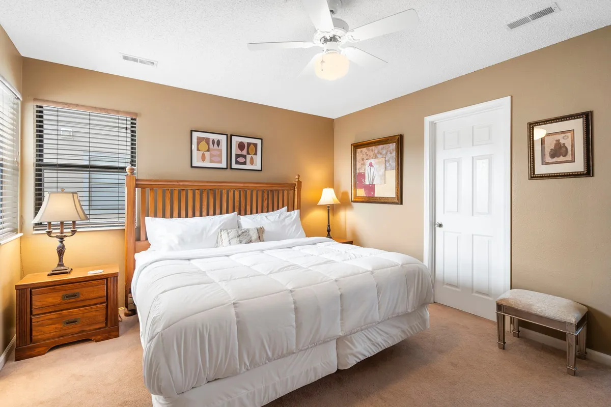 A tranquil bedroom setting with a comfortable bed, a nightstand featuring a lamp for gentle lighting, and tasteful artwork on the wall. The peaceful atmosphere makes it ideal for winding down and enjoying a good night's sleep.