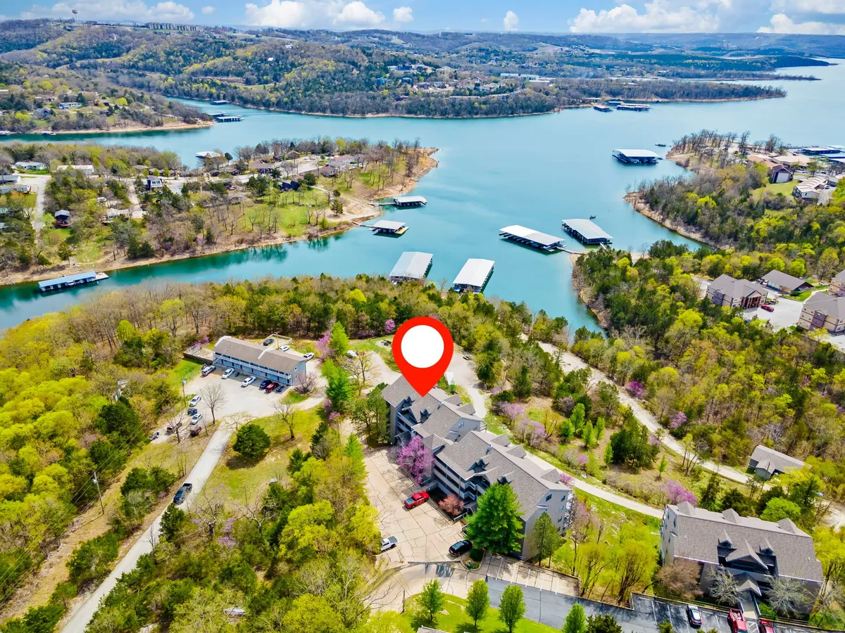 This image captures a tranquil lakeside scene with the property set against a backdrop of lush greenery, and the shimmering lake inviting activities such as boating, fishing, or simply relaxing by the water. The peaceful, inviting mood signals a place to recharge after a day of adventure.